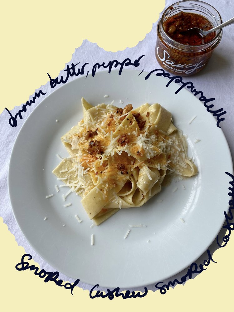Brown butter pepper pappardelle topped with grated Parmesan and smoked cashew