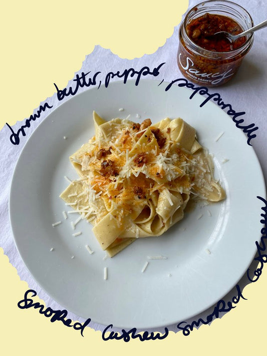 Brown butter pepper pappardelle topped with grated Parmesan and smoked cashew