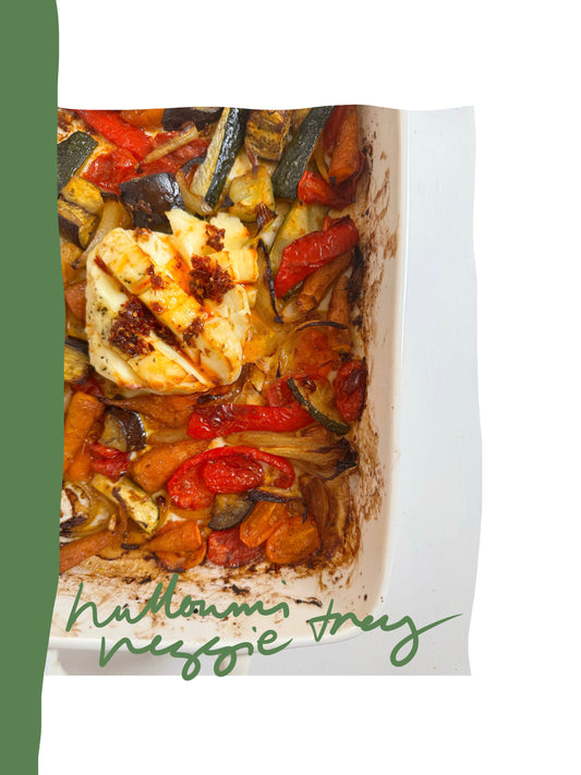 Golden halloumi slices glazed with honey and chilli sambal over roasted vegetables and butter beans in a baking tray.