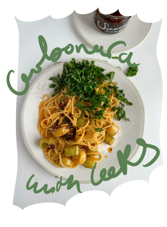 Spaghetti carbonara with roasted leeks, crispy kale, and Chilli Sambal on a white plate.