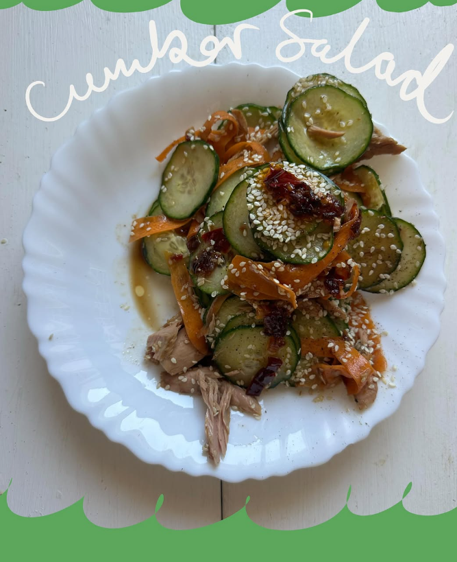 Viral cucumber salad with cucumber, carrot ribbons, tuna and chilli oil dressing on a white plate